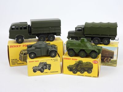 quatre véhicules militaires miniatures dans leurs boîtes, posés sur une surface blanche