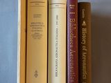 trois livres empilés les uns sur les autres sur un lit