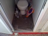 a toilet in the corner of a small bathroom