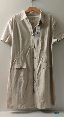 the shirt dress is hanging on a hanger on the wall