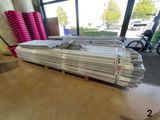 a pile of aluminum pipes on a pallet in a warehouse