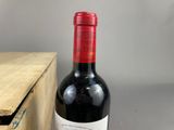 a bottle of red wine sitting next to a wooden box