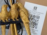 two golden birds sitting on top of a lamp