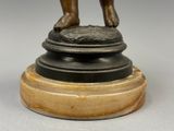 statue en bronze représentant une femme debout sur un piédestal, les mains sur les hanches
