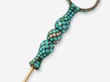 a close up of a metal object with turquoise beads on it