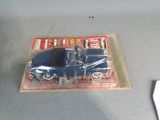 a blue toy car in a plastic package on a table