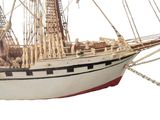 a model of a sailboat on display on a white surface