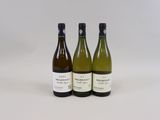 trois bouteilles de vin posées les unes à côté des autres sur une surface blanche
