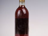 une vieille bouteille d'alcool posée sur une surface blanche