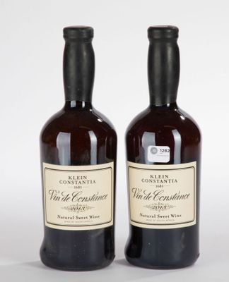 deux bouteilles de vin posées l'une à côté de l'autre sur une surface blanche