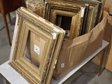 a lot of picture frames sitting on a table in a room