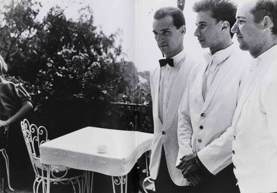 quatre hommes debout autour d'une table recouverte d'une nappe