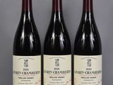 trois bouteilles de vin sont alignées sur une table