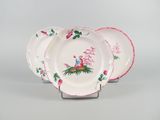 three pink and white plates with flowers and butterflies on them