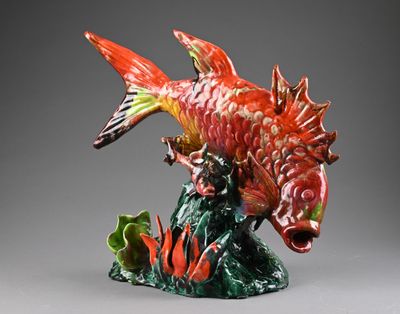 une figurine représentant un poisson posé sur une plante