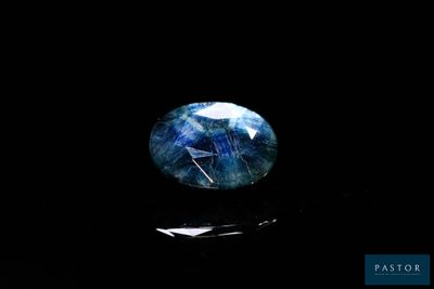 a close up of a blue and white stone on a black surface