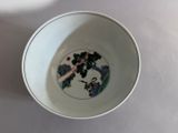 a white bowl with a painting on it sitting on a table