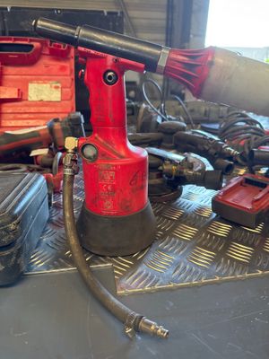 a red drill that is sitting on top of a table