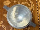 a silver bowl sitting on top of a wooden table