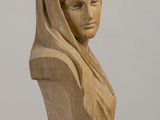 wooden bust of a woman with a veil on her head