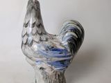 a ceramic chicken that is sitting on a table