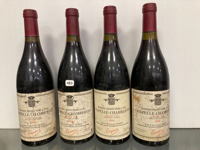 quatre bouteilles de vin sont alignées sur une table