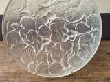 a glass plate with flowers on it sitting on a table
