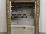 une image représentant un miroir à cadre doré posé sur un parquet
