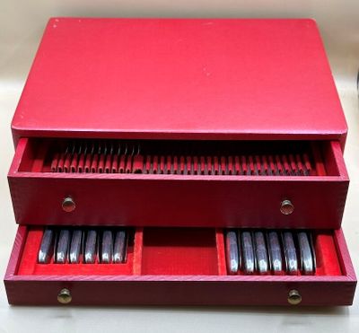 une image représentant une boîte rouge contenant un tas de stylos
