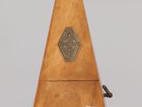 a small wooden instrument on display on a clear surface