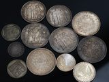 Plusieurs pièces d'argent sont disposées en cercle sur une surface noire