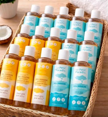 un panier rempli de nombreuses bouteilles de produits pour le bain, posé sur une table en bois