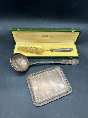 un service d'argenterie dans un coffret contenant une cuillère et un repose-cuillère