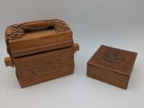 two small wooden boxes with lids and handles on a white surface