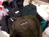 a suitcase full of clothes and a jacket sitting on the floor