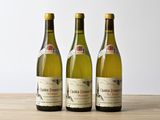 trois bouteilles de vin posées sur une table en bois