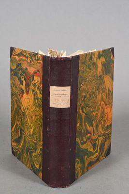 an old book with a yellow and green cover sitting on top of a table