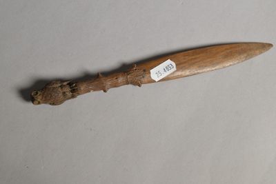 un couteau en bois muni d'une étiquette, posé sur une table