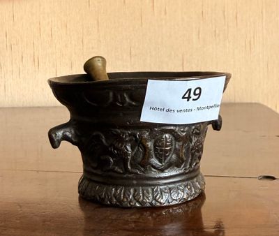 un petit vase en métal muni d'une étiquette, posé sur une table