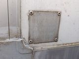 a metal plaque on the side of a white wall