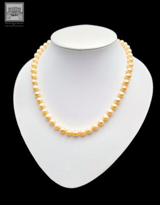 a white necklace with yellow pearls on a mannequin