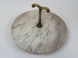a white marble plate with a brass t on it
