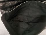 a black purse that is open on a white surface