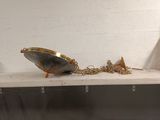 a silver and gold object on a shelf next to a white wall