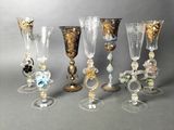 several glass goblets and wine glasses are lined up on a table