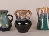 three different colored vases sitting next to each other on a table