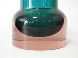 a green glass vase with a copper rim on a white background