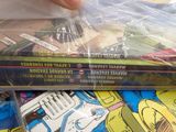 a stack of comic books sitting on top of a pile of other comics