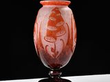 a red vase with a design on it on a table