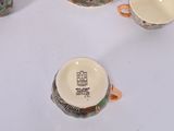 several cups and saucers sitting on a table with a white table cloth
